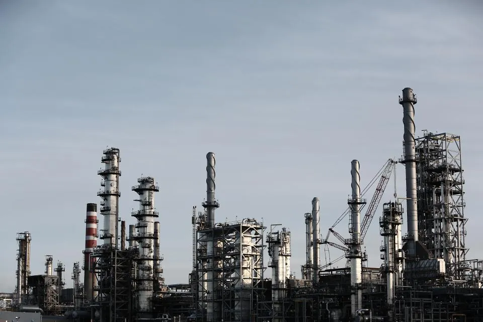 Refinery towers and piping against a cloudy sky